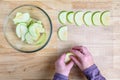 WomanÃ¢â¬â¢s hands taking granny smith apple slices out of a glass bowl and laying them out on a mesh tray for dehydrating Royalty Free Stock Photo